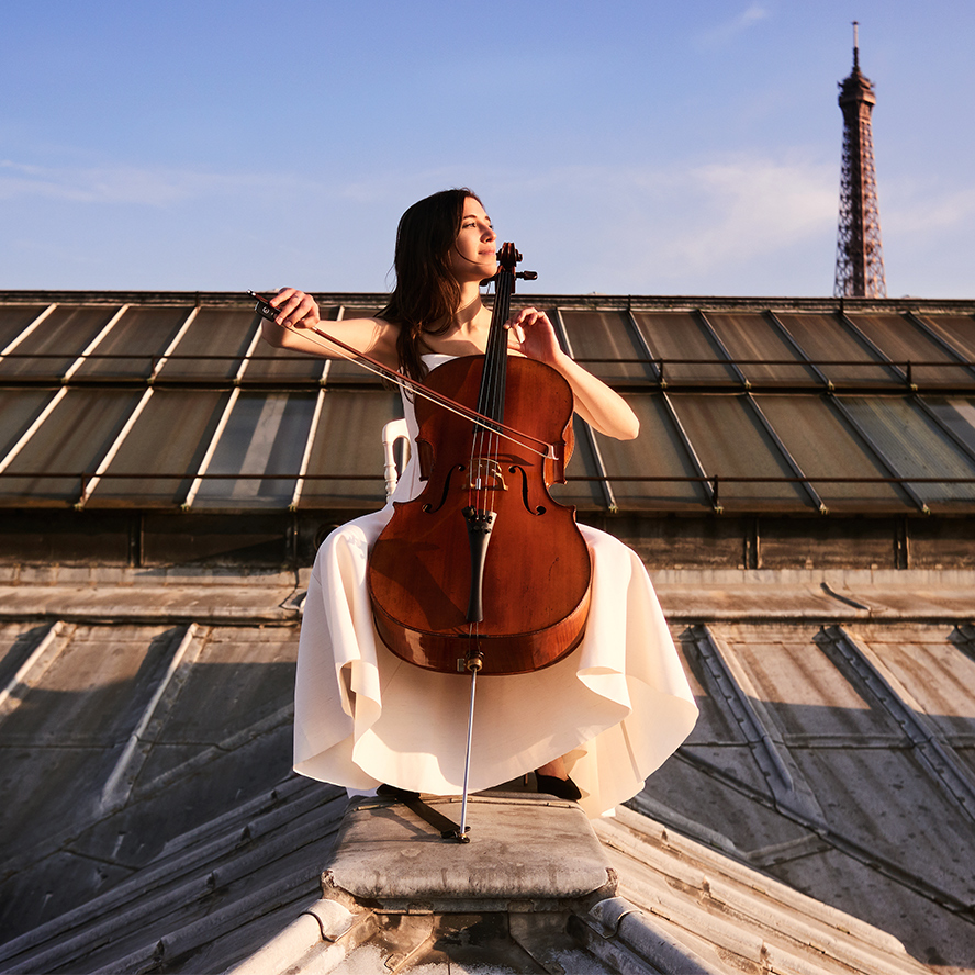 Camille Thomas with cello on top of a building